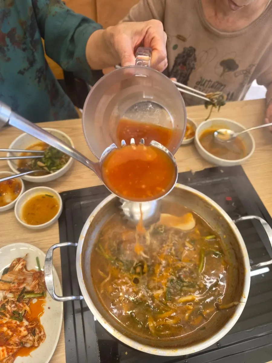 Plate of minari and potatoes scooped out of the pot