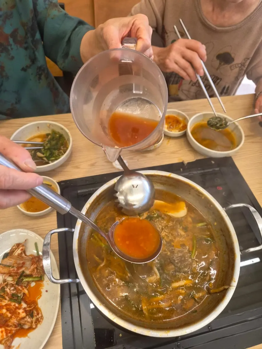 Scooping vegetables out of the shabu-shabu broth