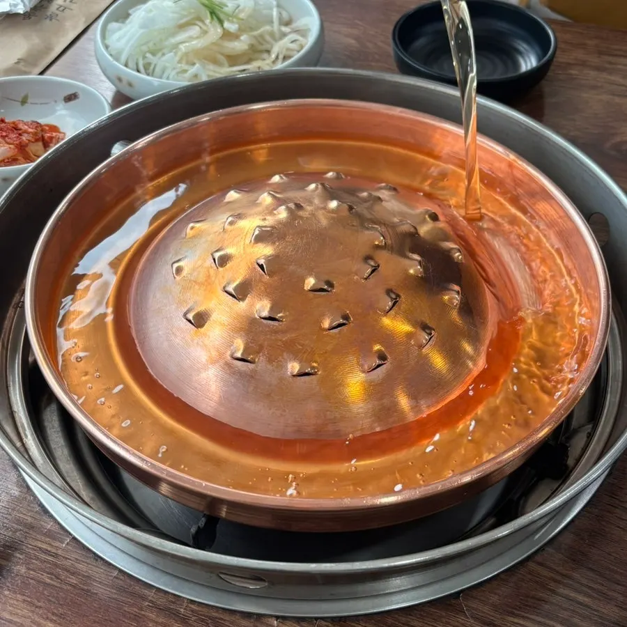 Plate of pickled onions, seasoned radish, kimchi, and other side dishes