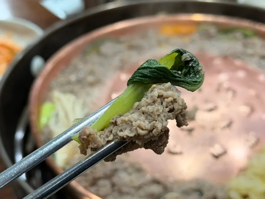Verduras cocinándose en el caldo del borde de la parrilla