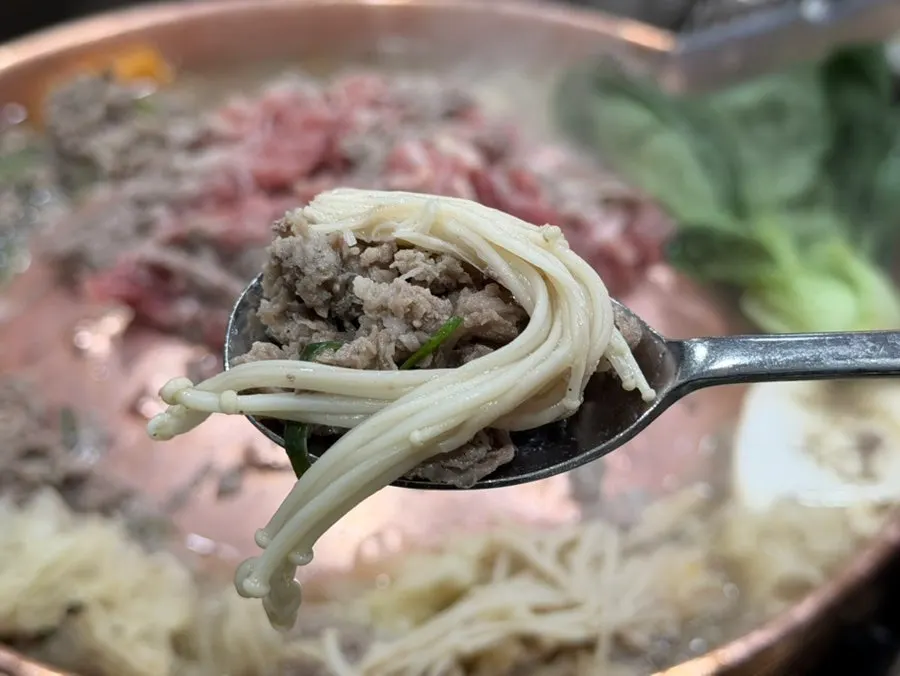 Añadiendo bulgogi fresco a la parrilla