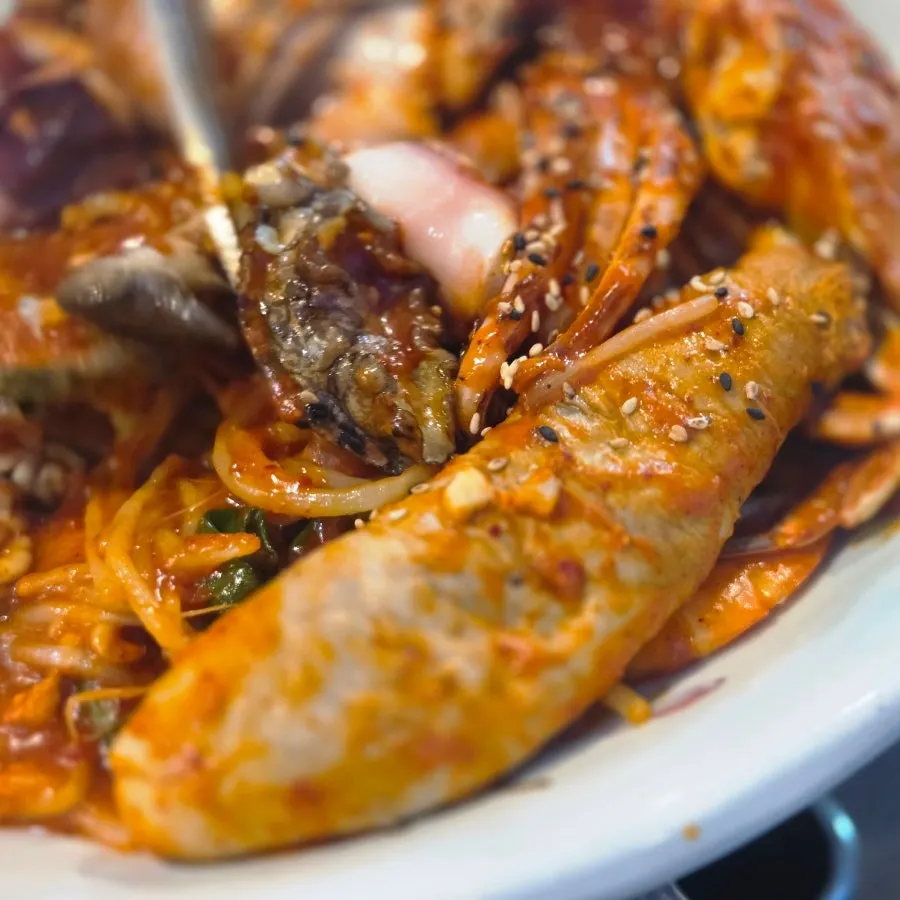 Table with raw fish and seafood stew laid out