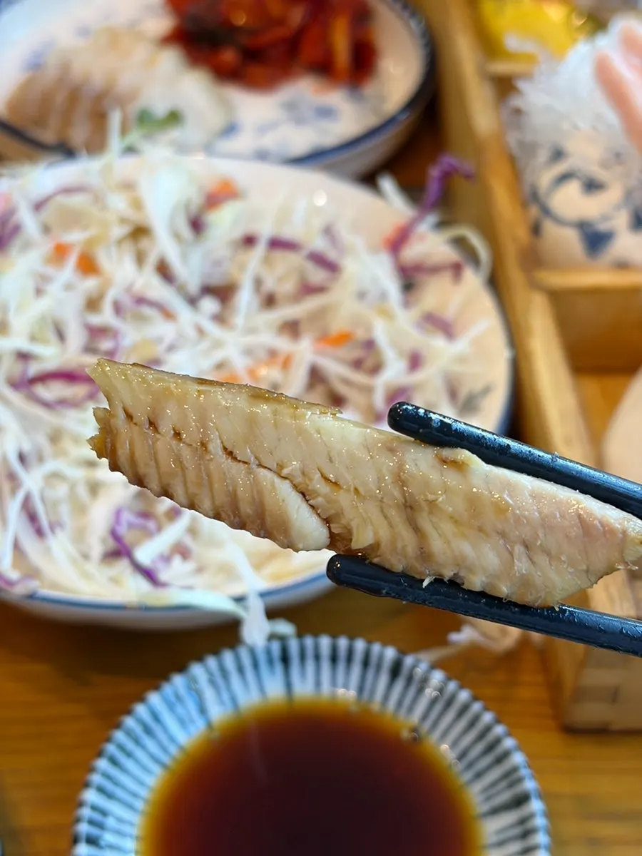 A piece of sashimi placed on aged kimchi