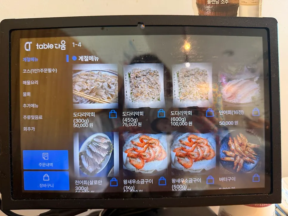 Menu board listing sashimi platter, seafood soup and seafood stew
