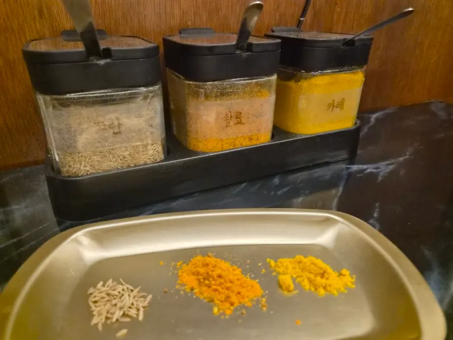 3 powder sauces on the table: cumin, chwallyo, and curry