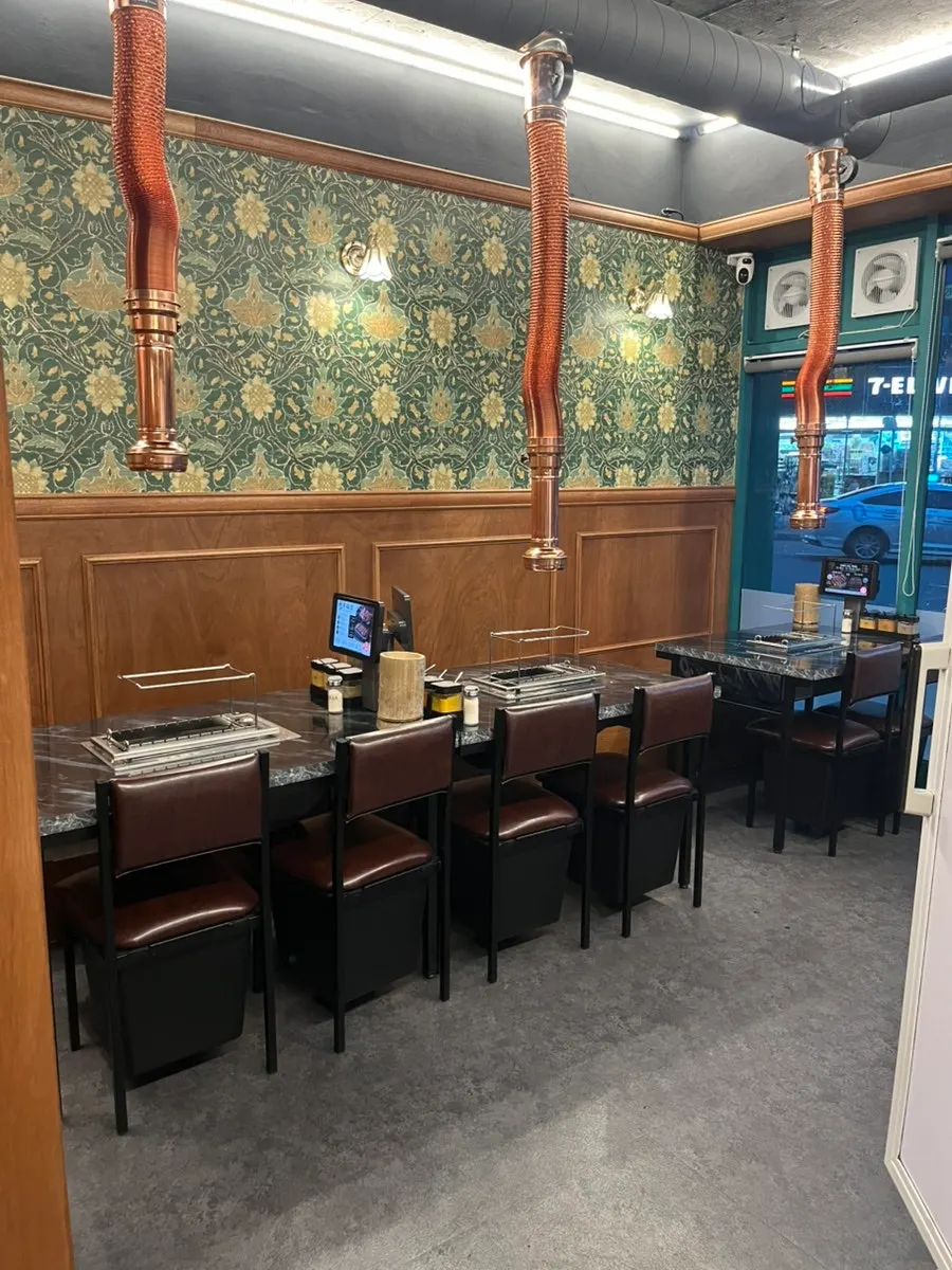 Space on the left side of the restaurant with 6- and 8-person tables