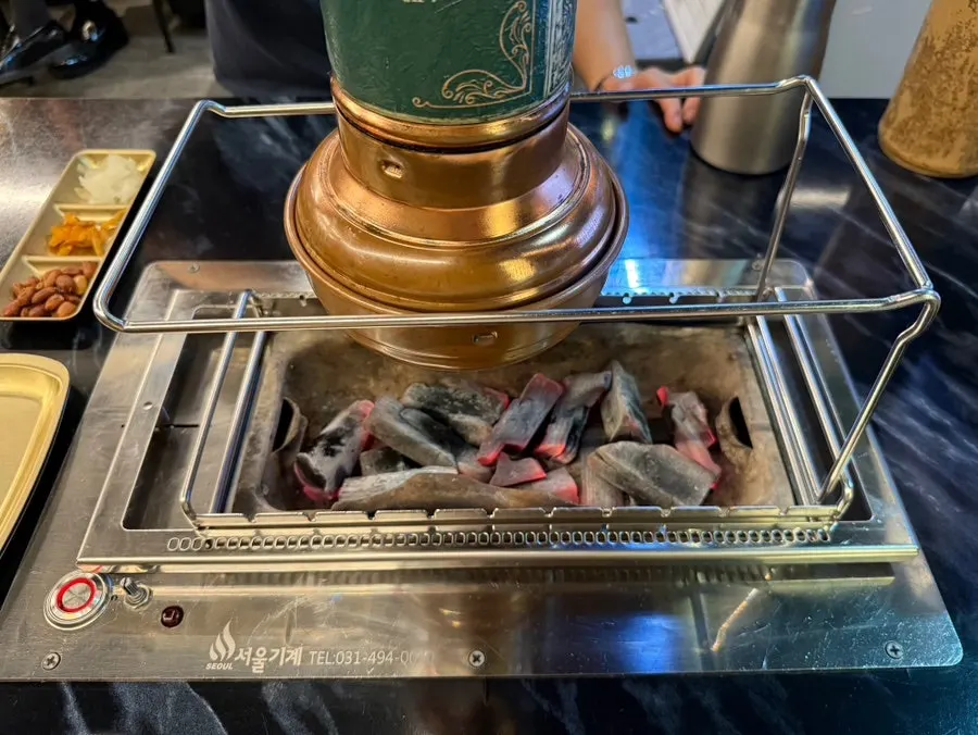 Rotating lamb skewer grill loaded with charcoal
