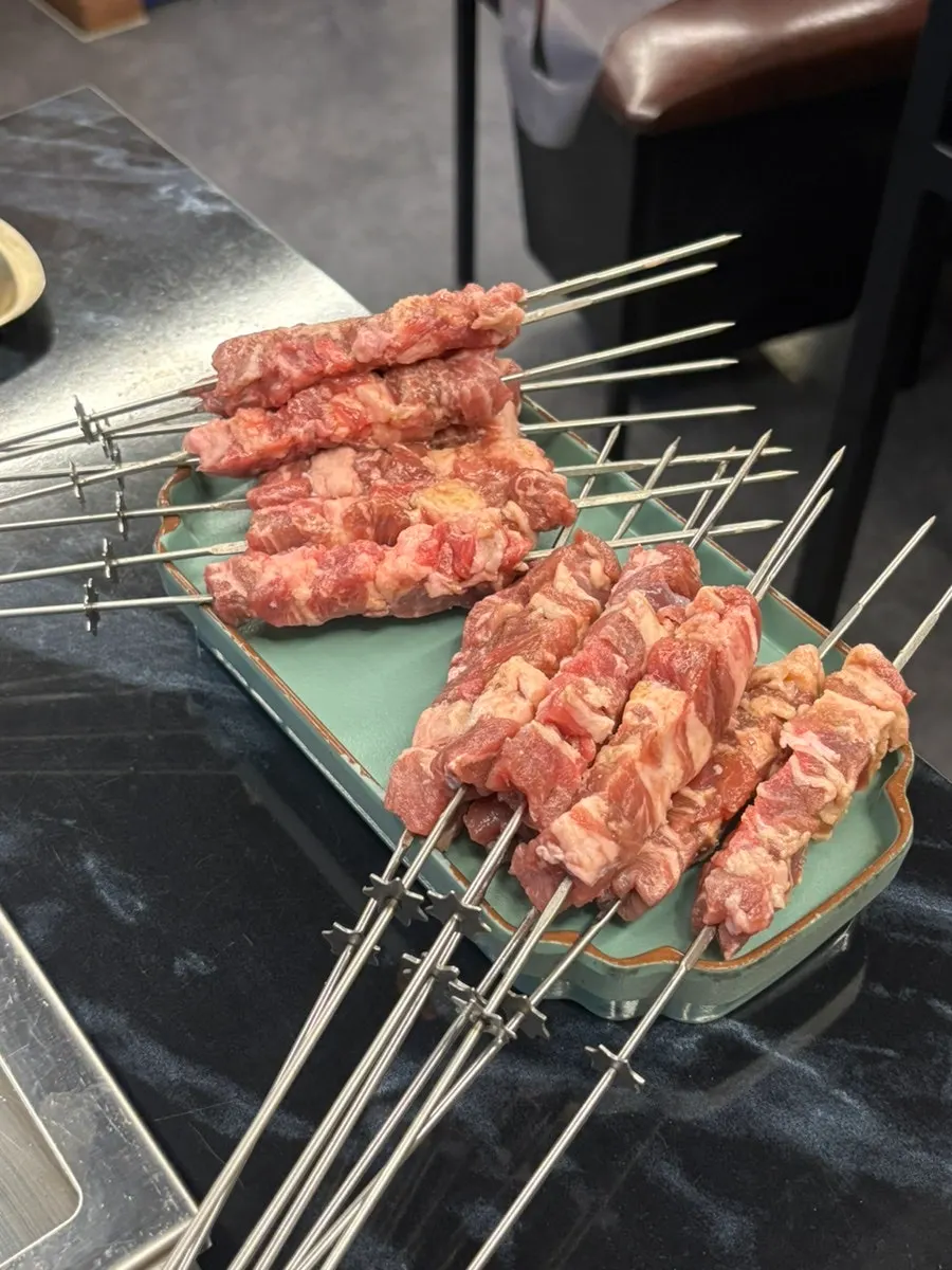 A plate with one serving each of wangyangkkochi and lamb sirloin skewers