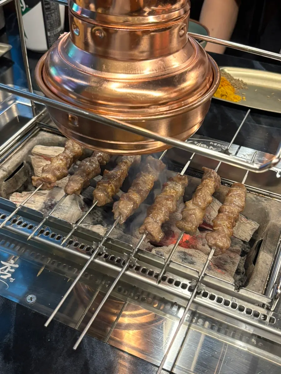 Lamb skewers on the automatically rotating skewer machine