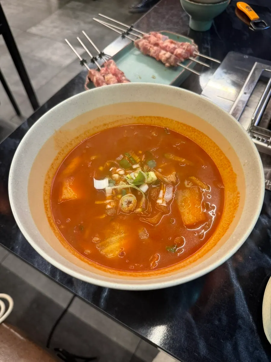 A bowl of okmyeon in red spicy broth