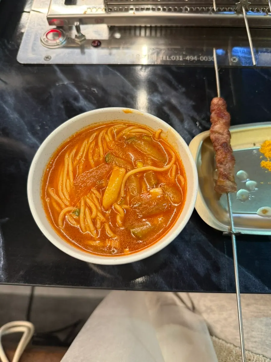 Chewy corn noodles lifted out of the okmyeon