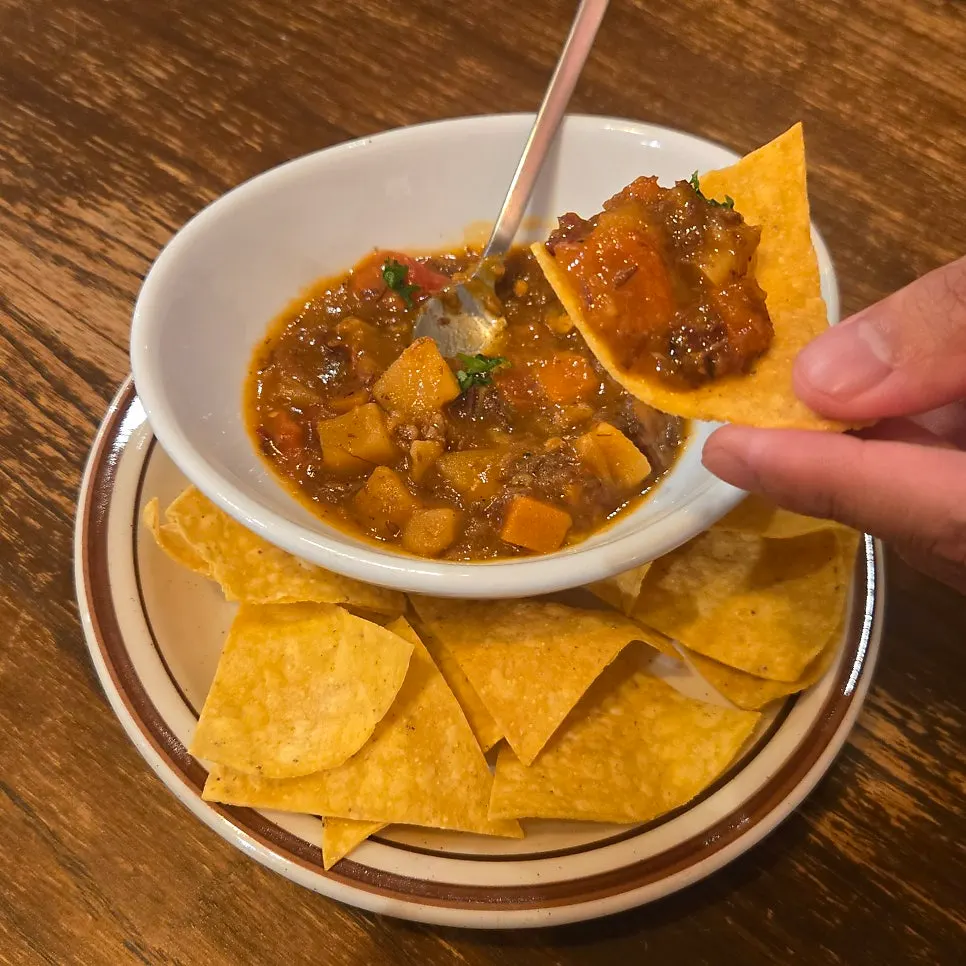 Warm appetizer stew served with nacho chips