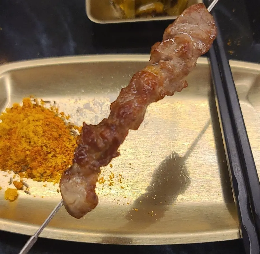 Lamb skewers cooking over charcoal