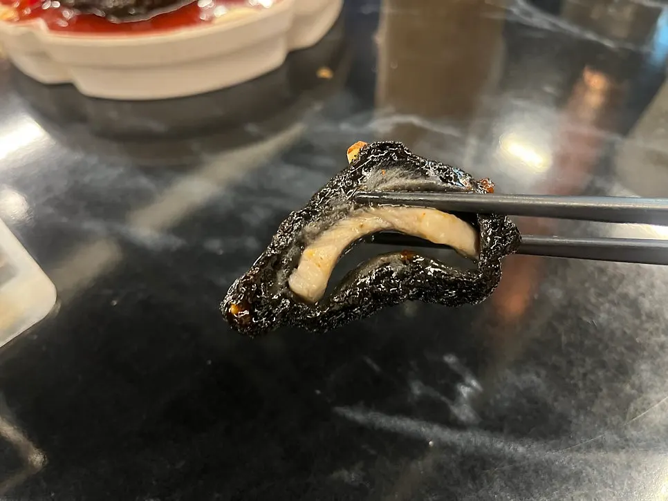 Cross-section of black quabaorou with gochujang-based sauce