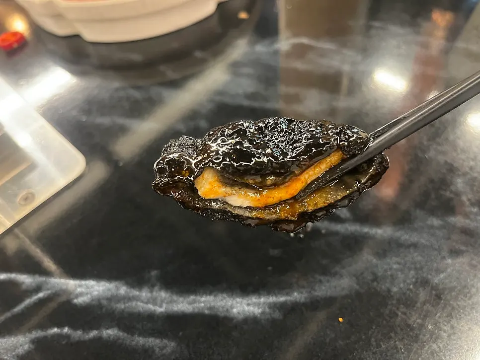 Black quabaorou served alongside lamb skewers