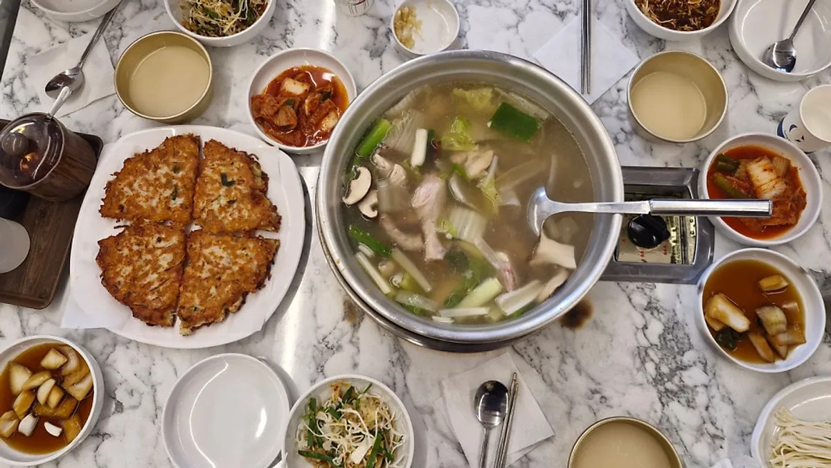 Table spread of meat mung bean bindaetteok and dak hanmari