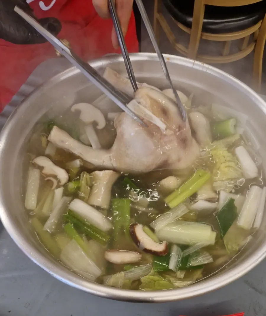 Whole chicken hot pot served in a large metal bowl