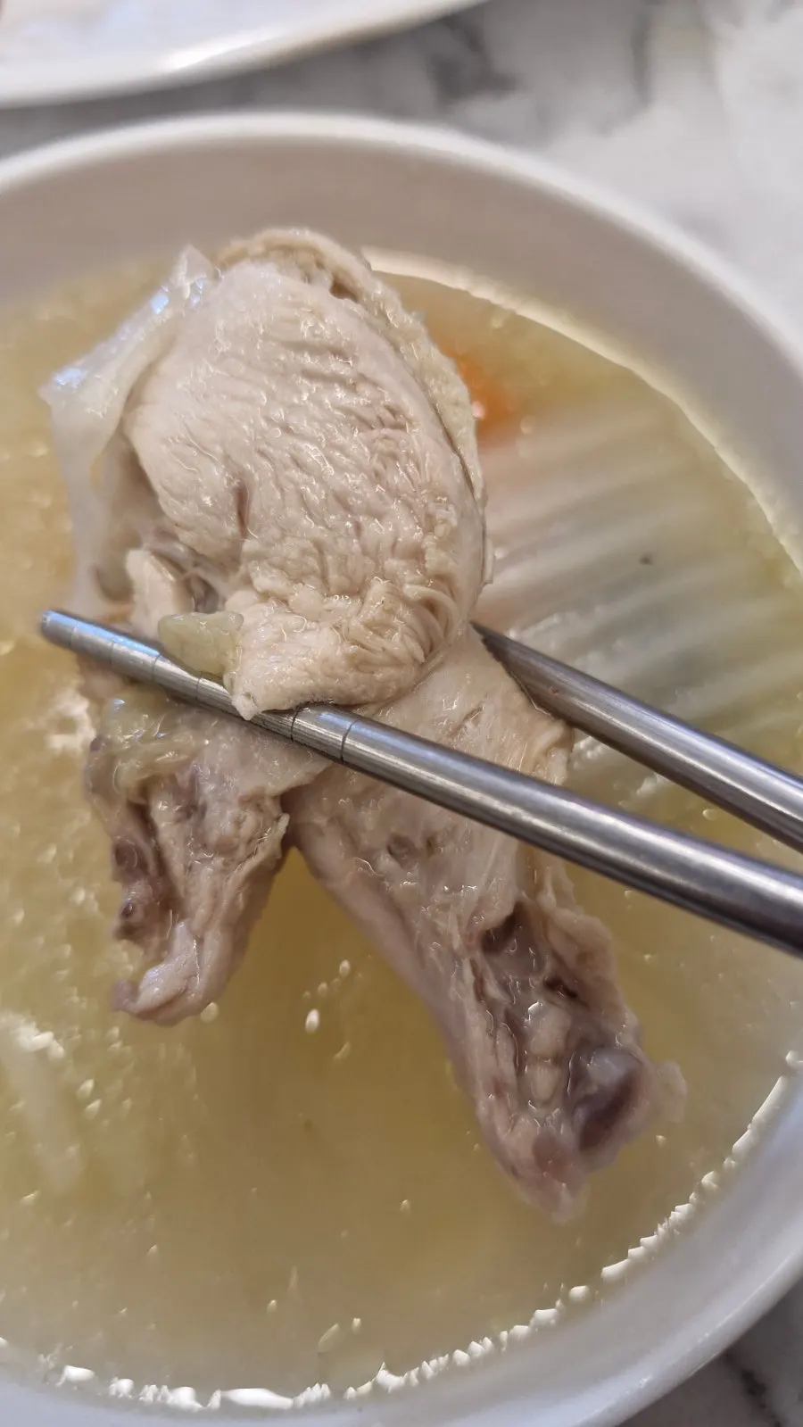 A piece of chicken dipped in the sauce