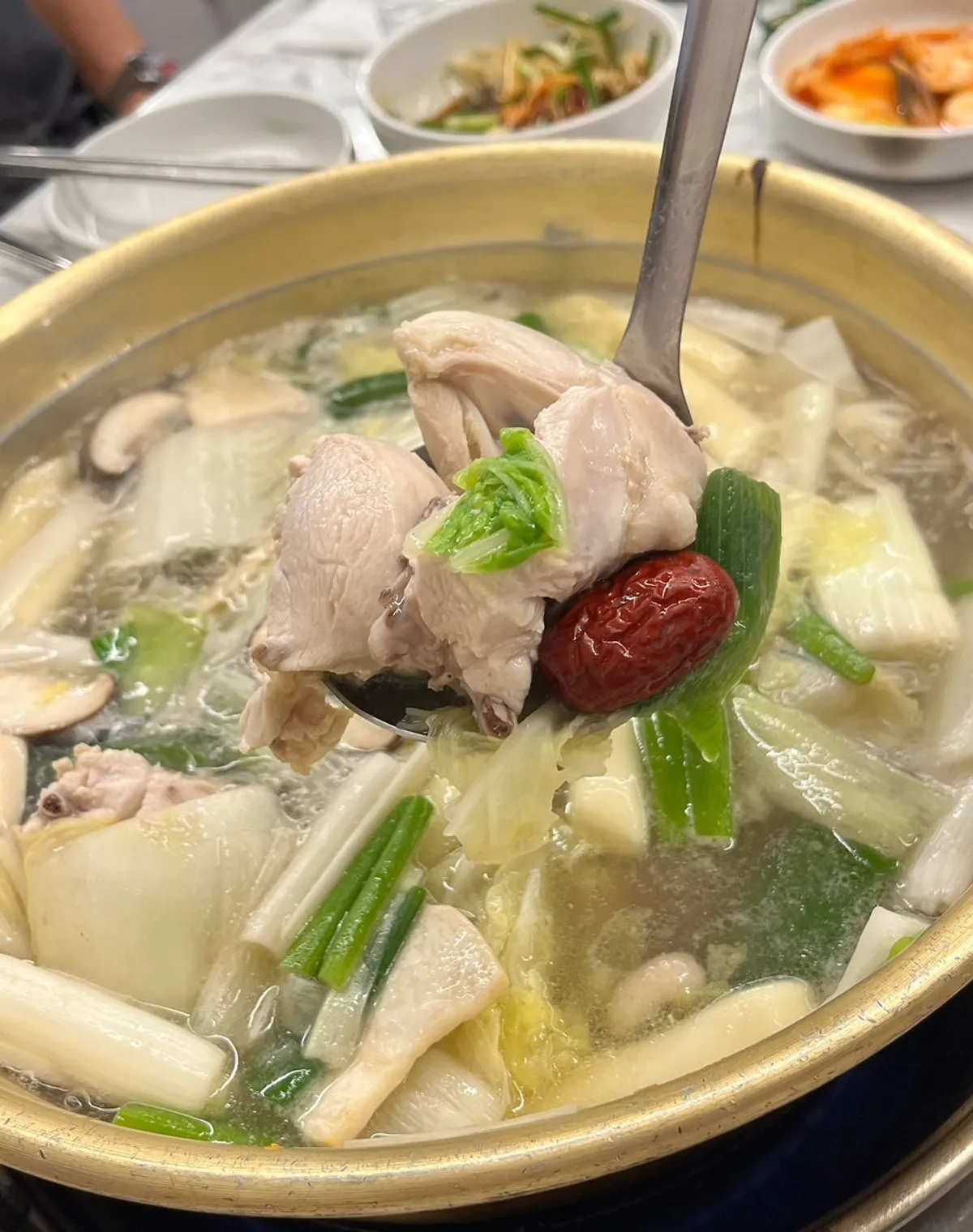 Whole chicken with vegetables, rice cake, jujube, and ginseng in a large basin