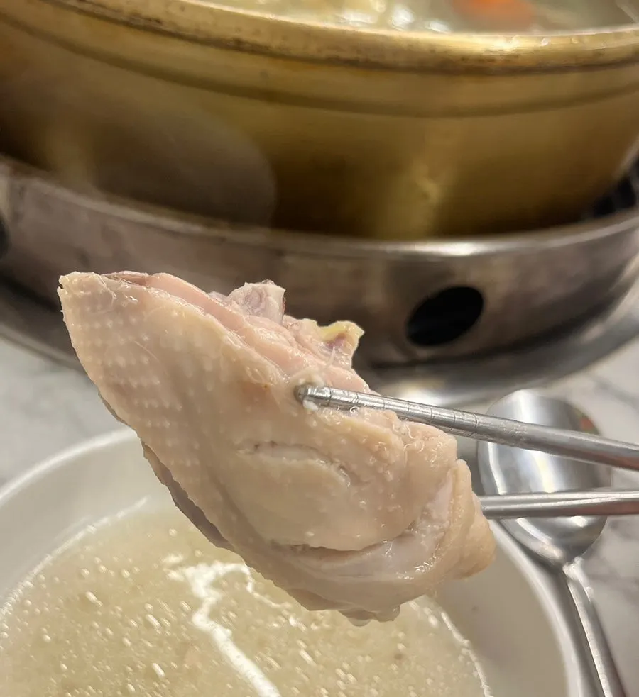 A piece of chicken dipped in the sauce