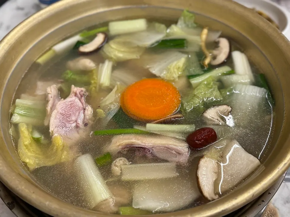 Dak hanmari boiling in a large metal bowl