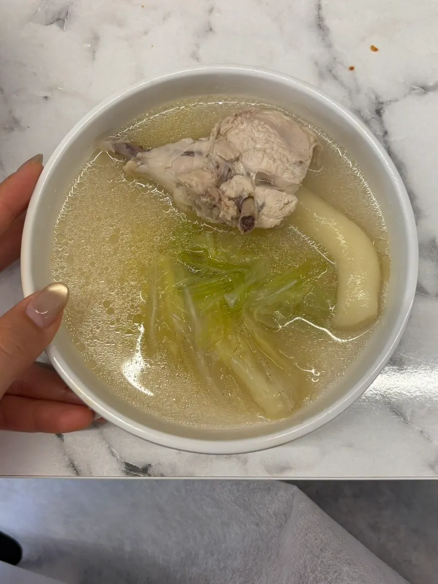 Chicken leg and rice cakes lifted out of the pot