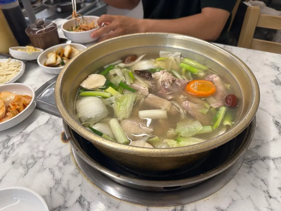 Chicken, green onion and rice cake in a brass pot