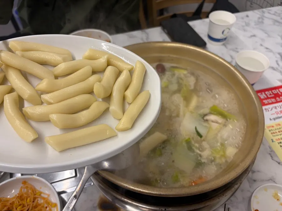 A piece of dak hanmari rice cake fished out of the pot