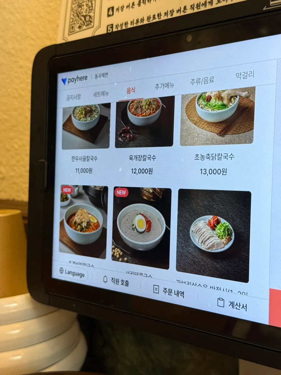Donggok Jemyeon menu board listing noodles and Korean side dishes