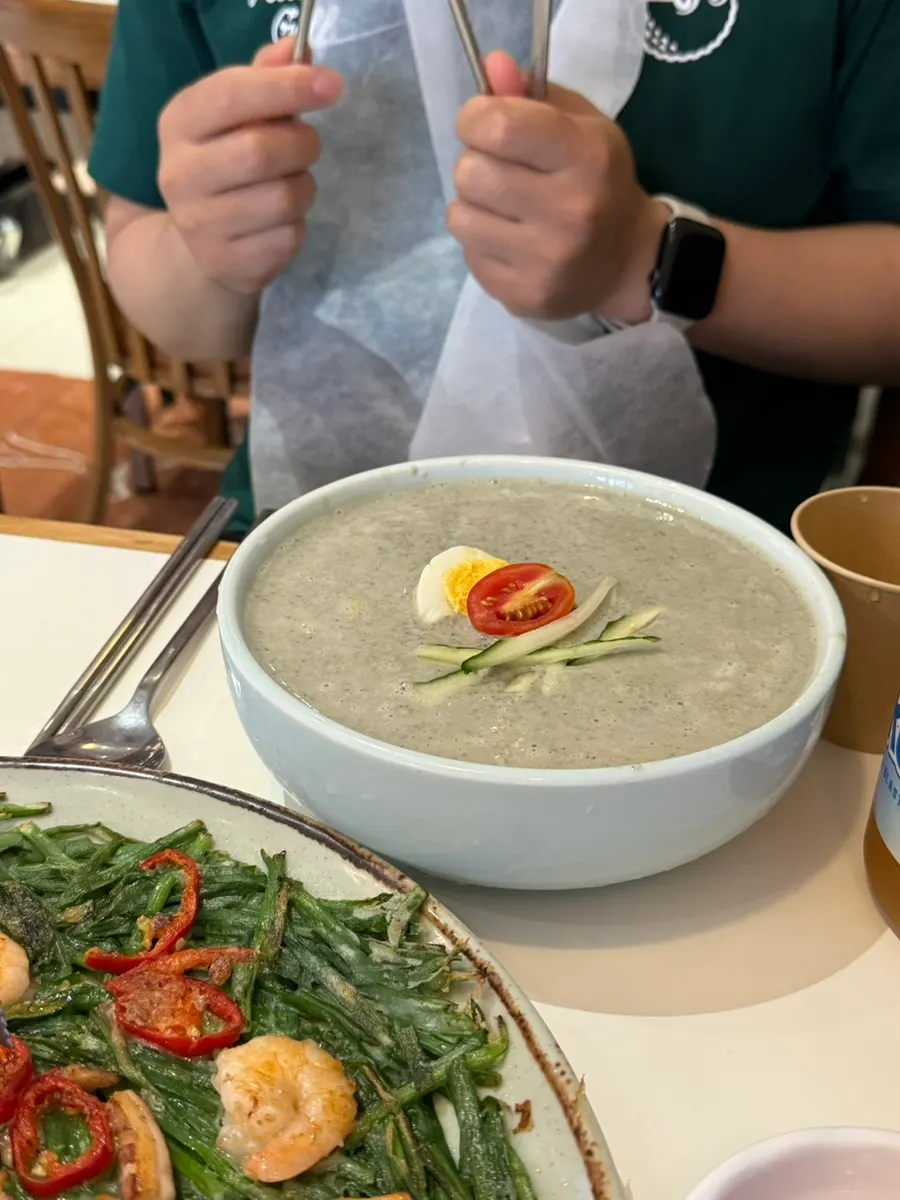 Seoritae kongguksu topped with egg, cherry tomato and cucumber