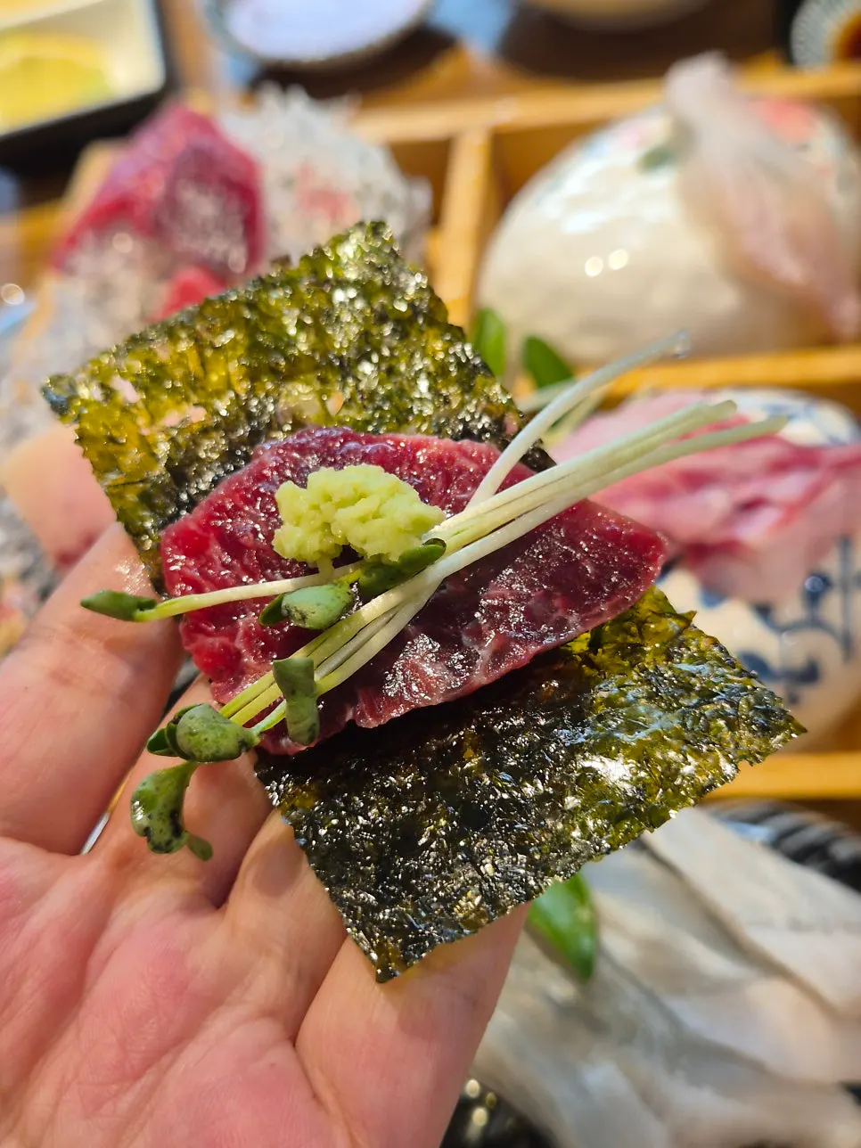 A bite of tuna sashimi wrapped in seaweed
