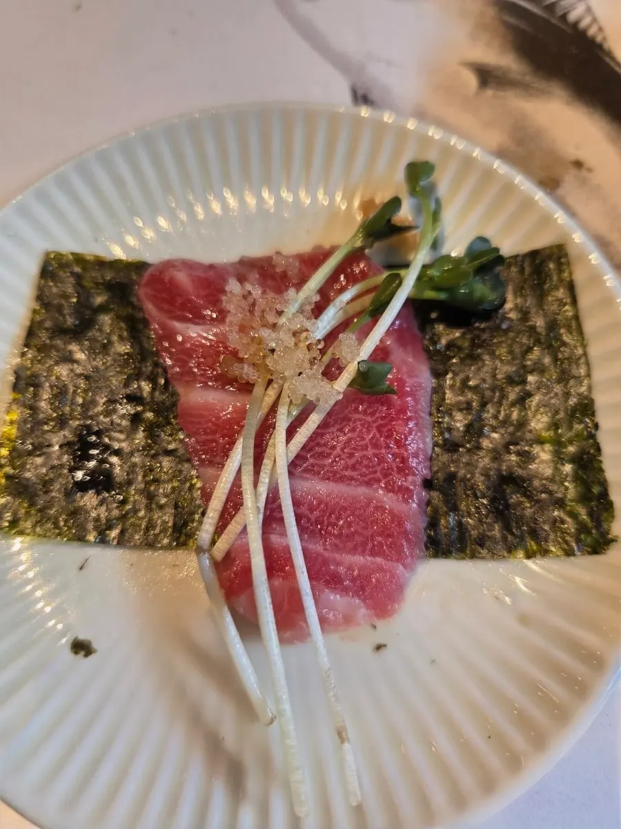 Combining several cuts of tuna sashimi in one bite