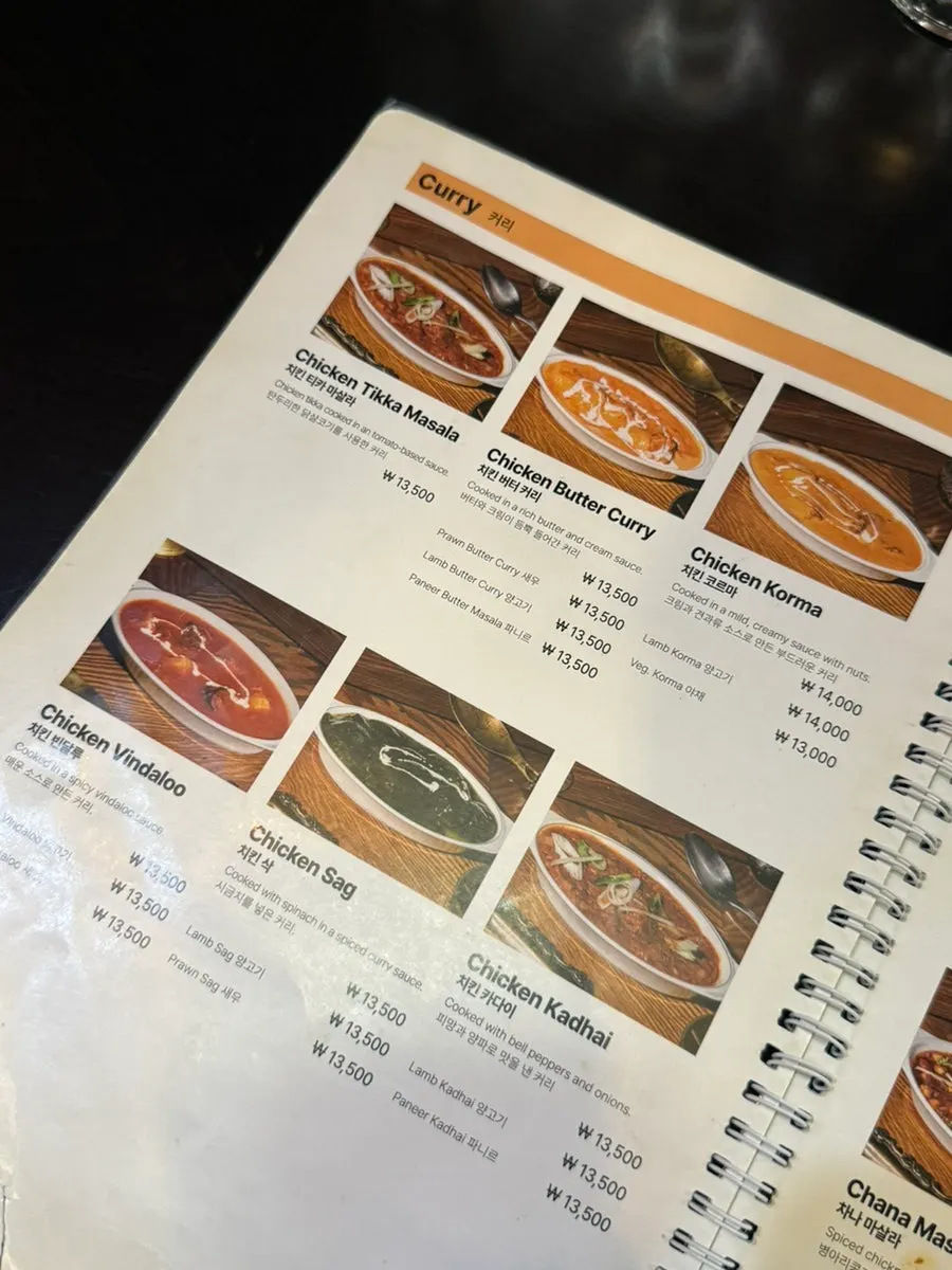 Menu board listing curries, naan and tandoori dishes