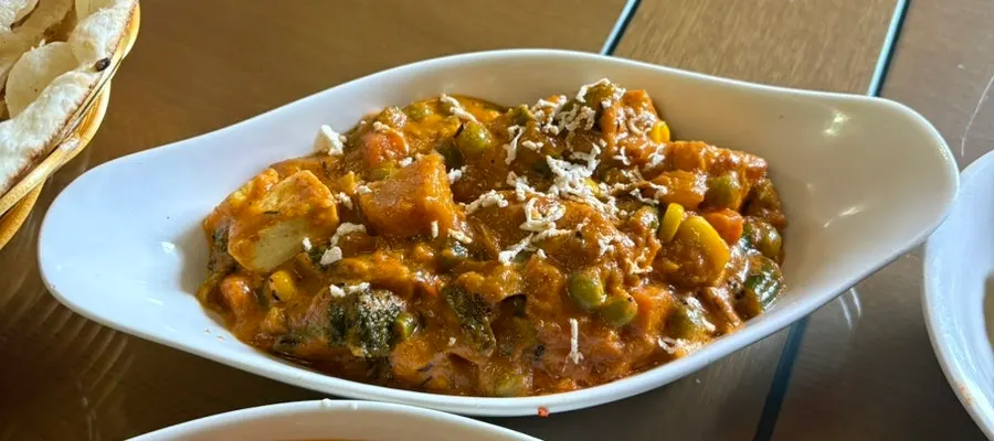 Garlic naan dipped into chicken makhani
