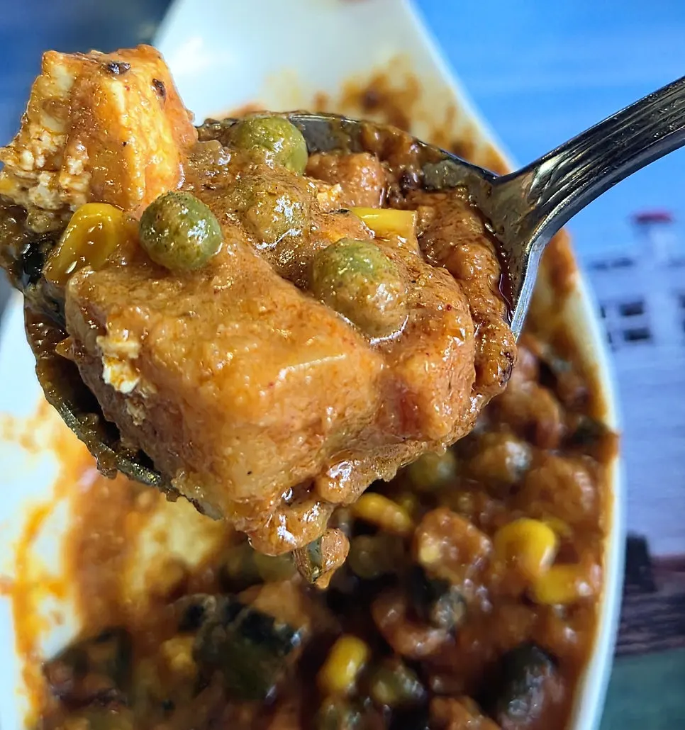 Two bowls of chicken makhani and vegetable curry