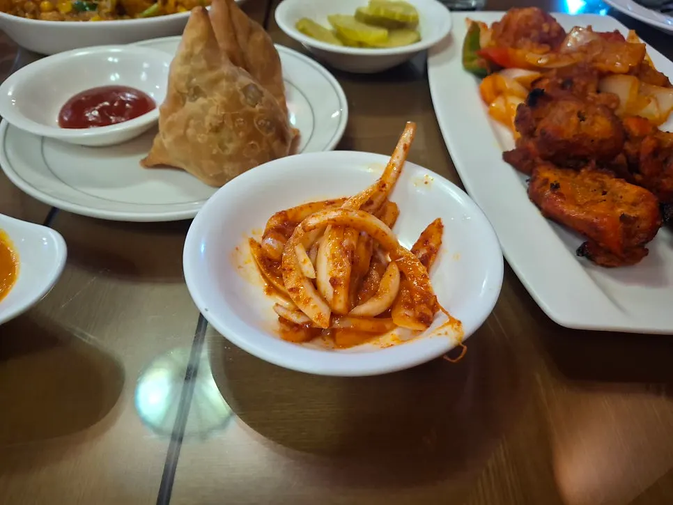 Photo of samosas and spicy dressed onions