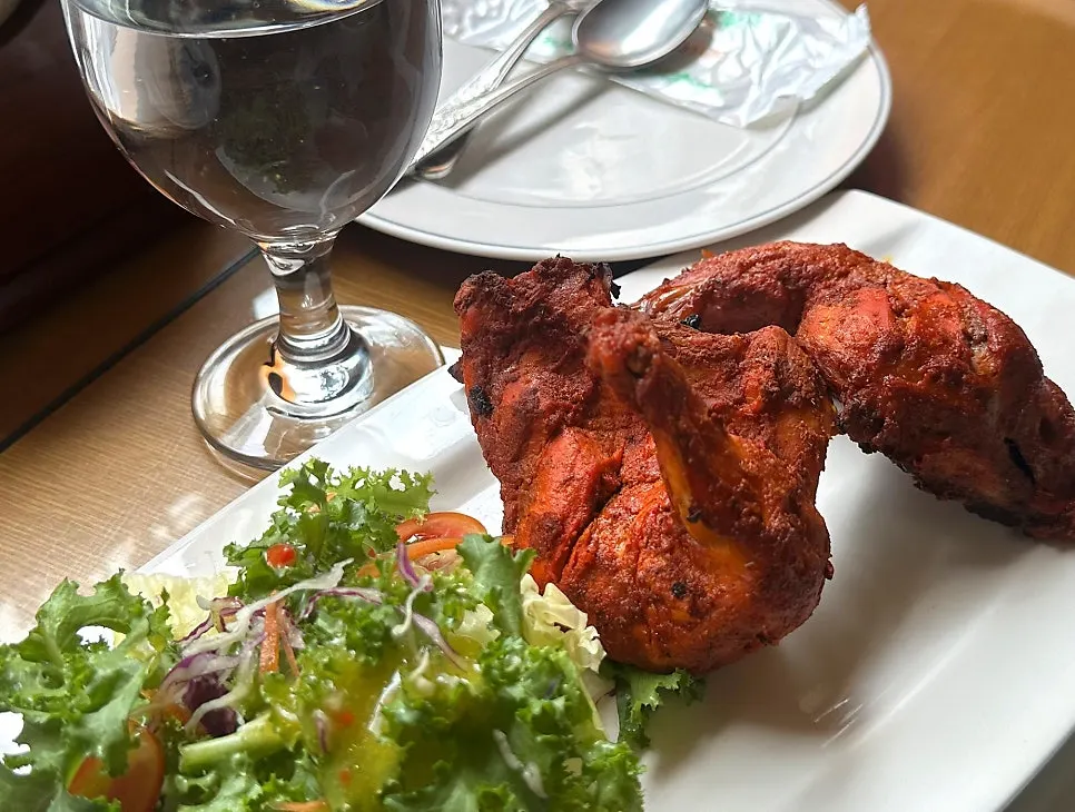A spread of curry, naan and tandoori chicken laid out together