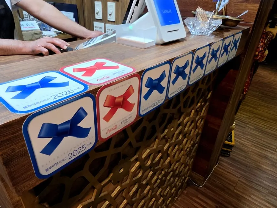 Entrance decorated with Blue Ribbon and other restaurant award stickers