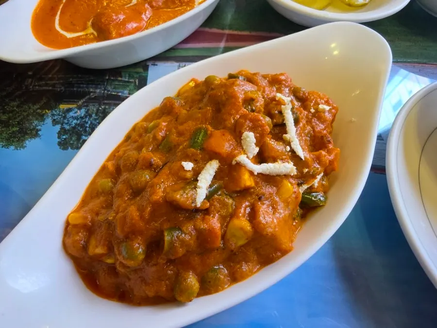 Vegetable curry packed with vegetables, served with garlic naan