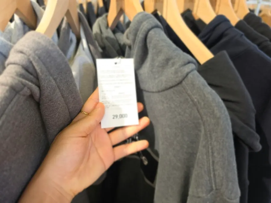 Store aisle packed with hanging clothes