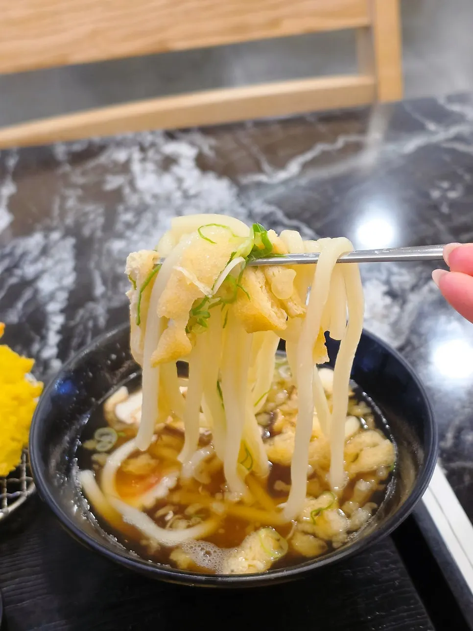 Mini udon topped with tempura flakes and fried tofu pouch