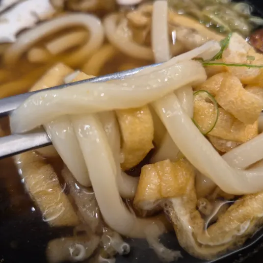Primer plano del udon con caldo dashi intenso