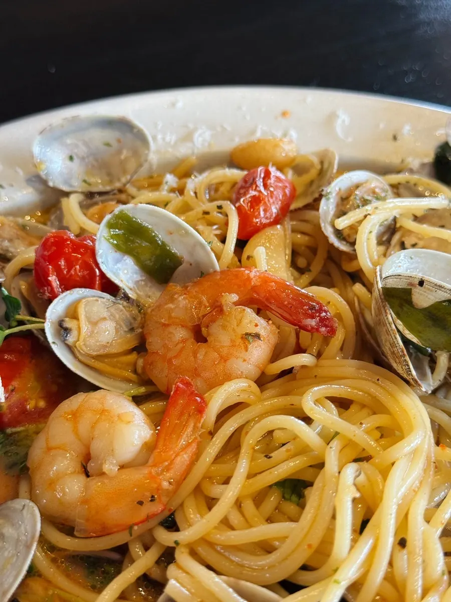 Picking up a clam from the pasta plate