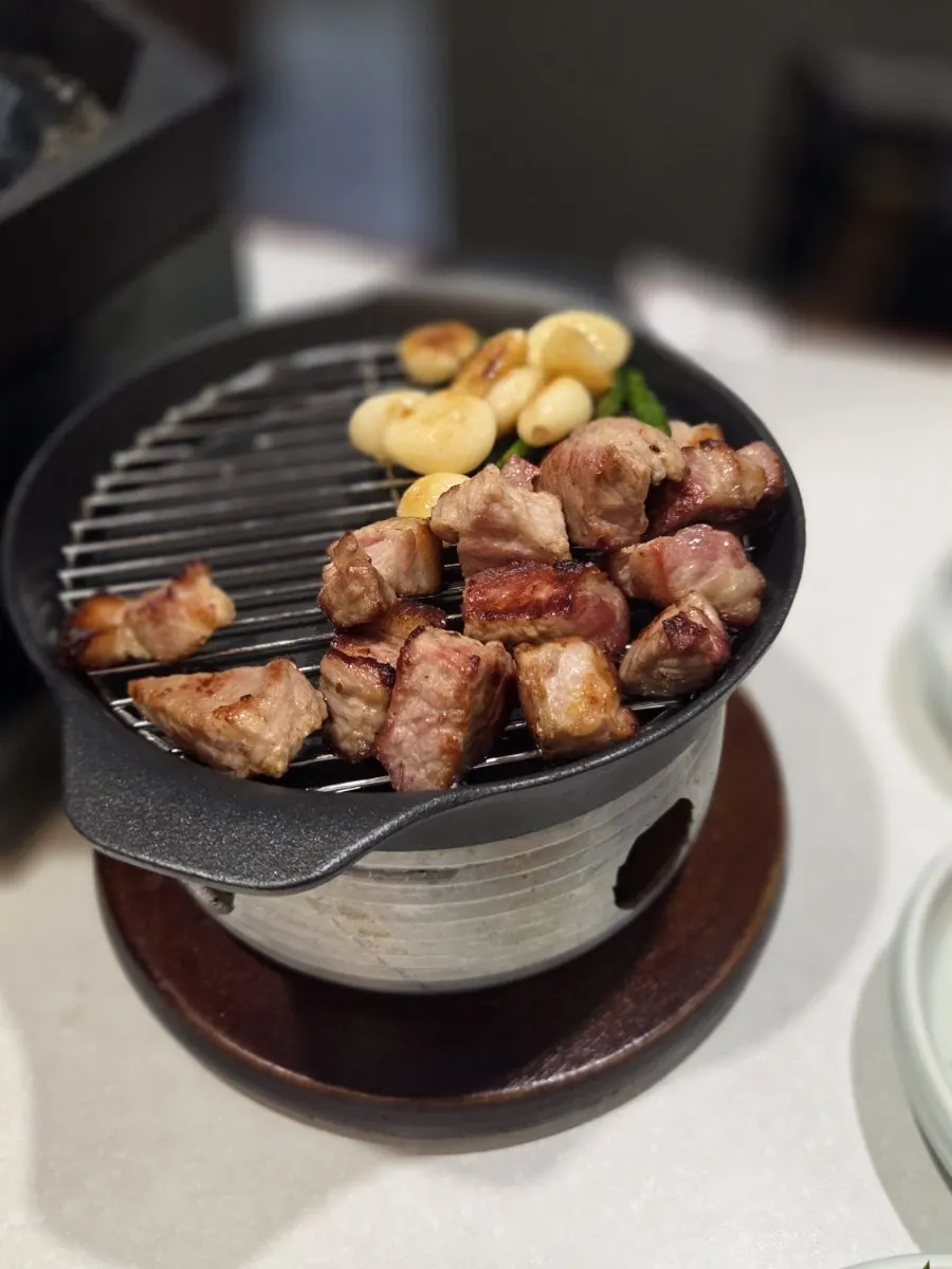 Staff member grilling meat on the pan
