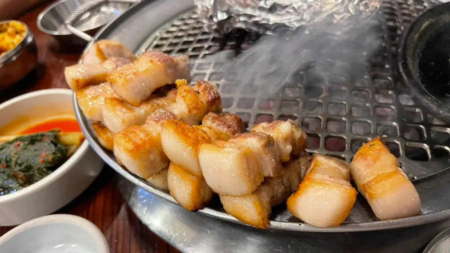 A thickly sliced piece of grilled whole pork belly