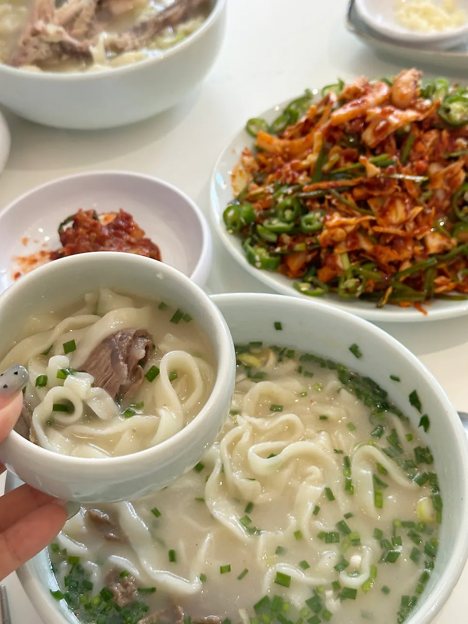 Homemade kalguksu noodles lifted up with chopsticks