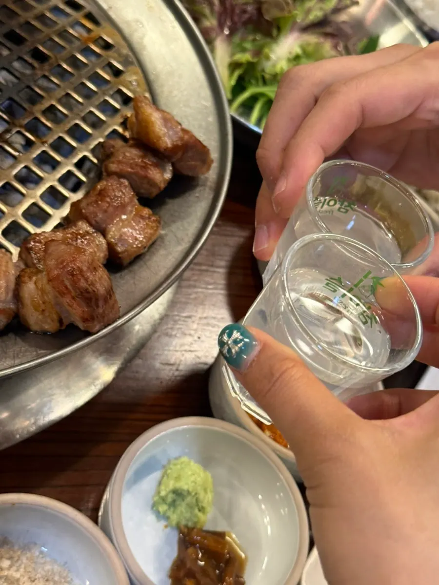 A soju glass set alongside the meat