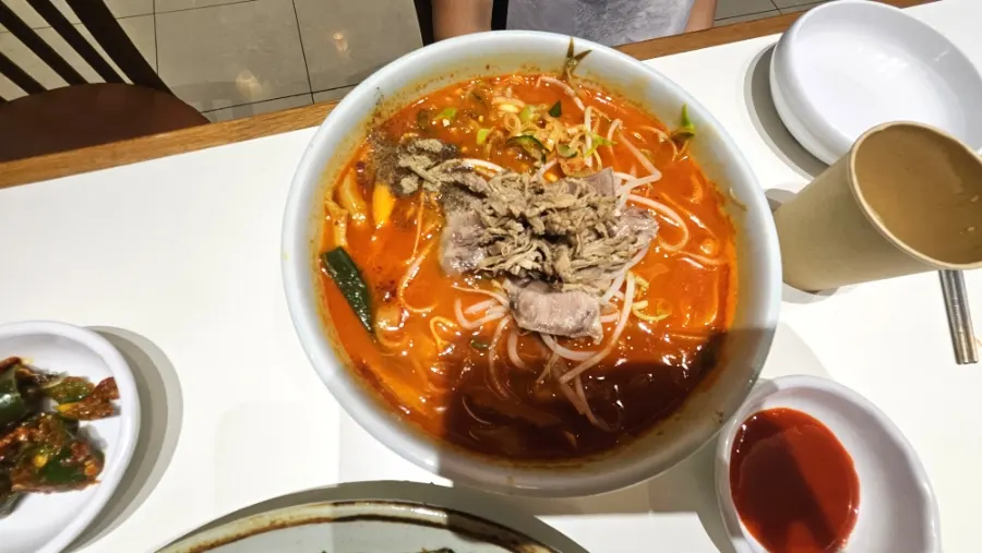 닭고기와 국물이 담긴 칼국수 그릇