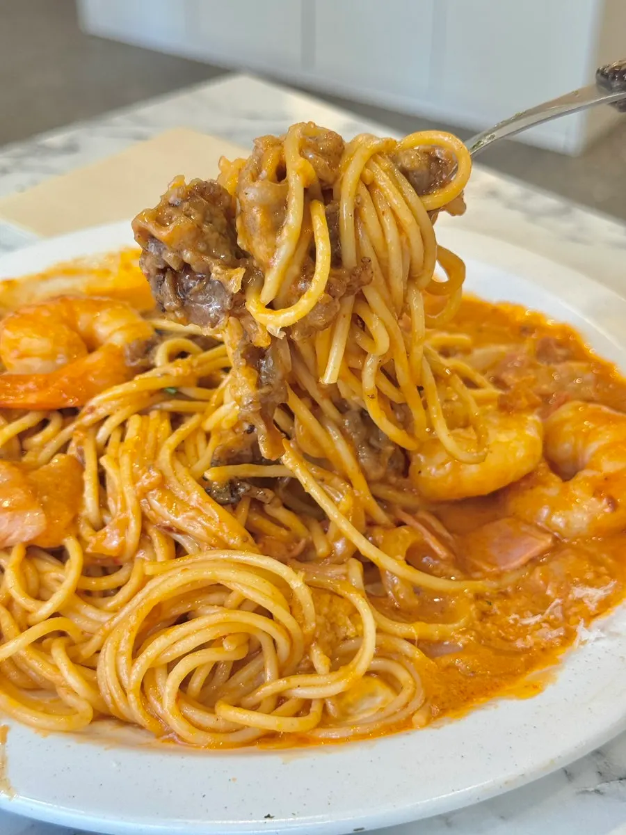 Noodles of the mala rosé pasta lifted on a fork
