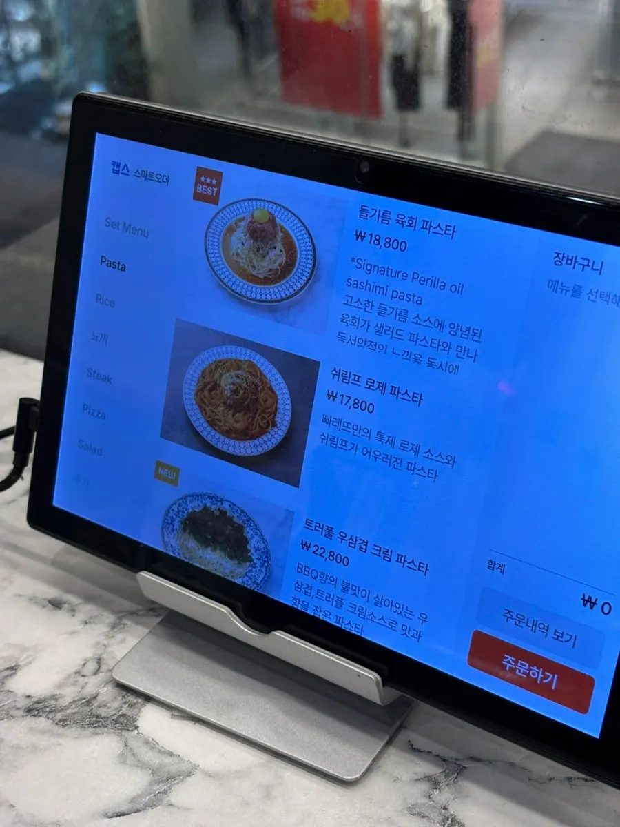 Menu board listing pasta types and prices